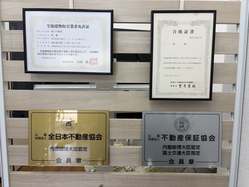 春山不動産の宅地建物取引業免許証と合格証書、全日本不動産協会・不動産保証協会の会員章